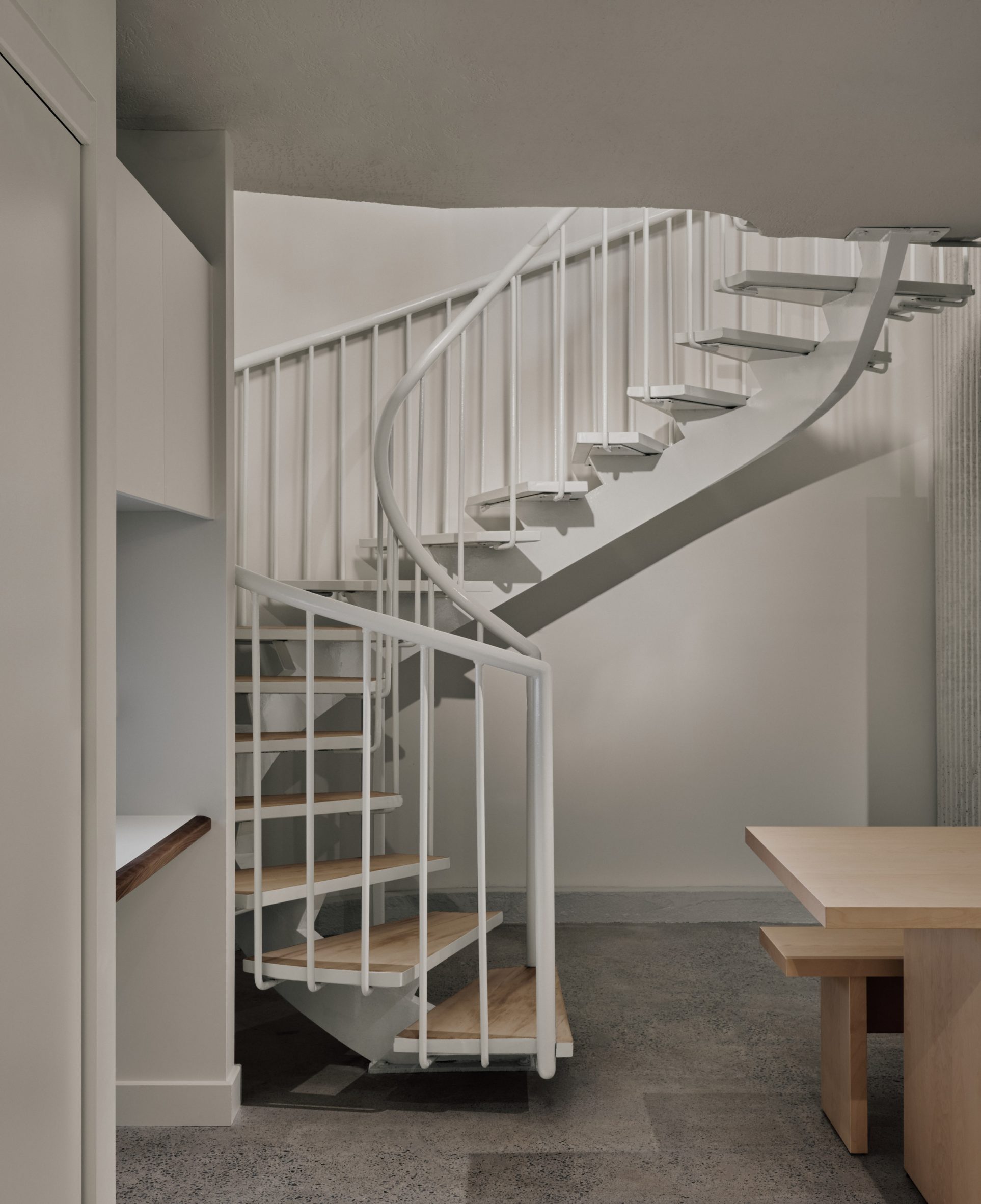 A spiral staircase leads down to a staff area in a basement
