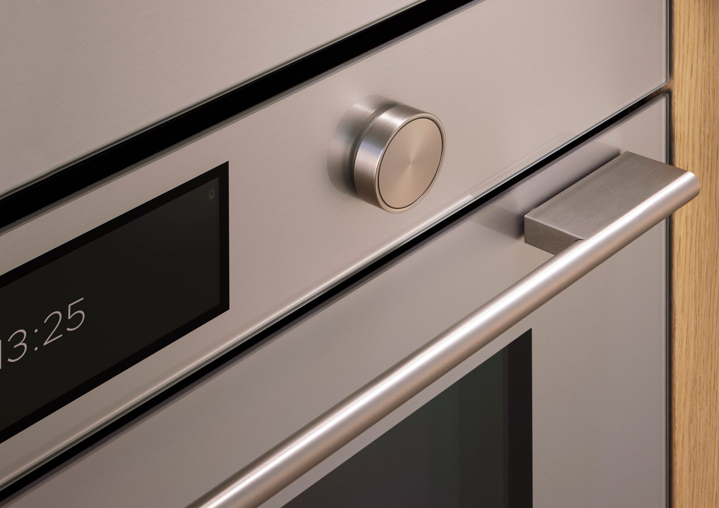 Close-up image of a Fisher & Paykel contemporary oven showing a soft, subtly reflective coloured finish with a precisely machined knob next to a touchscreen
