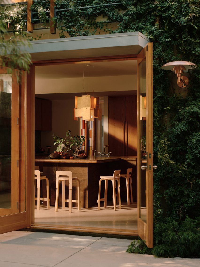 A kitchen island clad in rust-toned stone with an aged, tactile finish