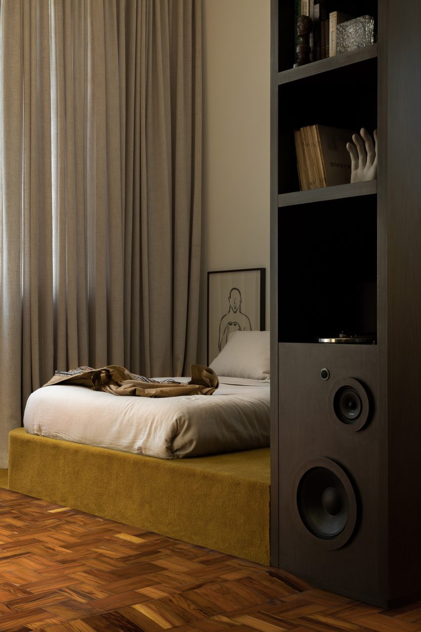 Walnut built-ins divide a living area from a sleeping quarters