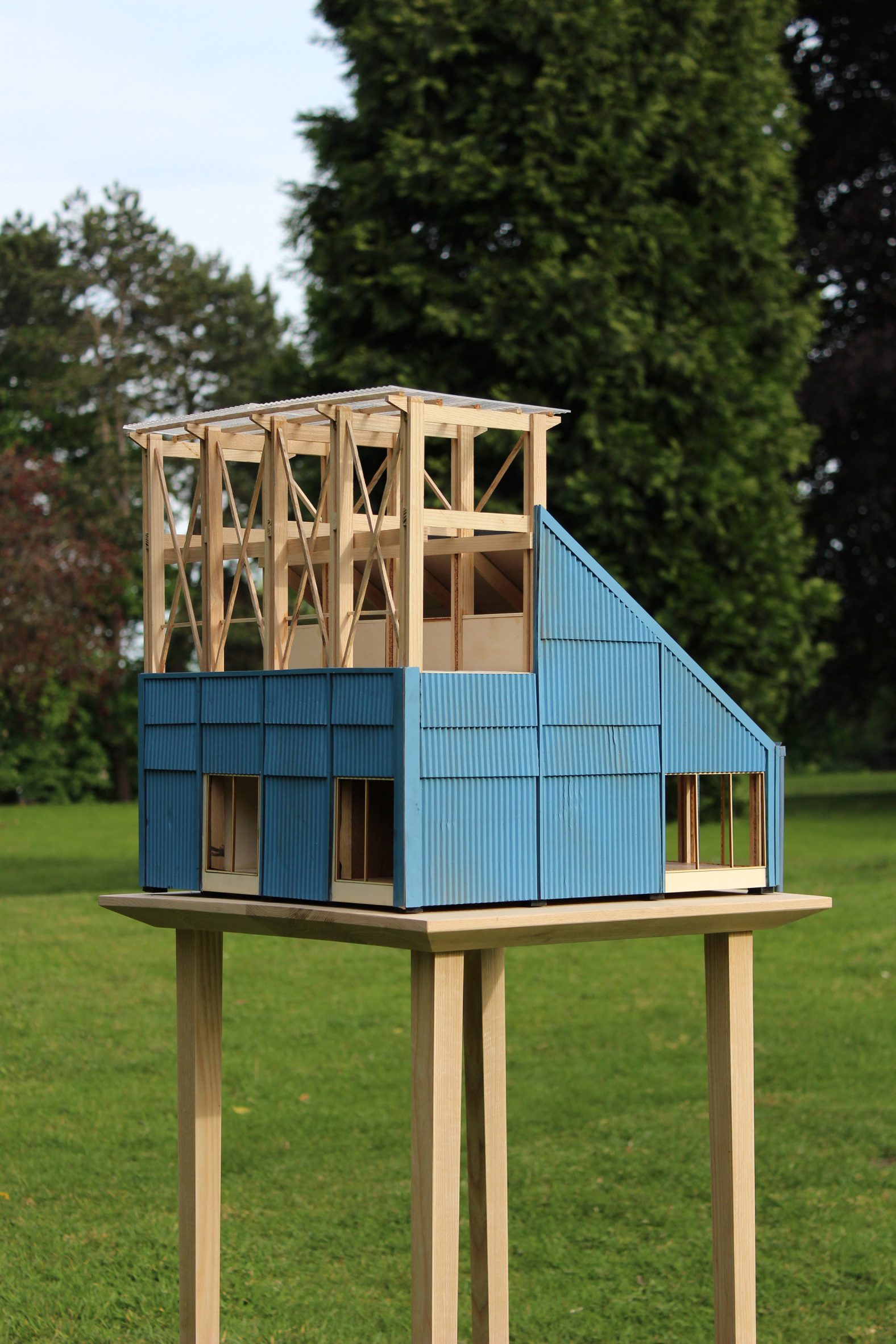 Architectural model with blue cladding and wooden structure photographed outside