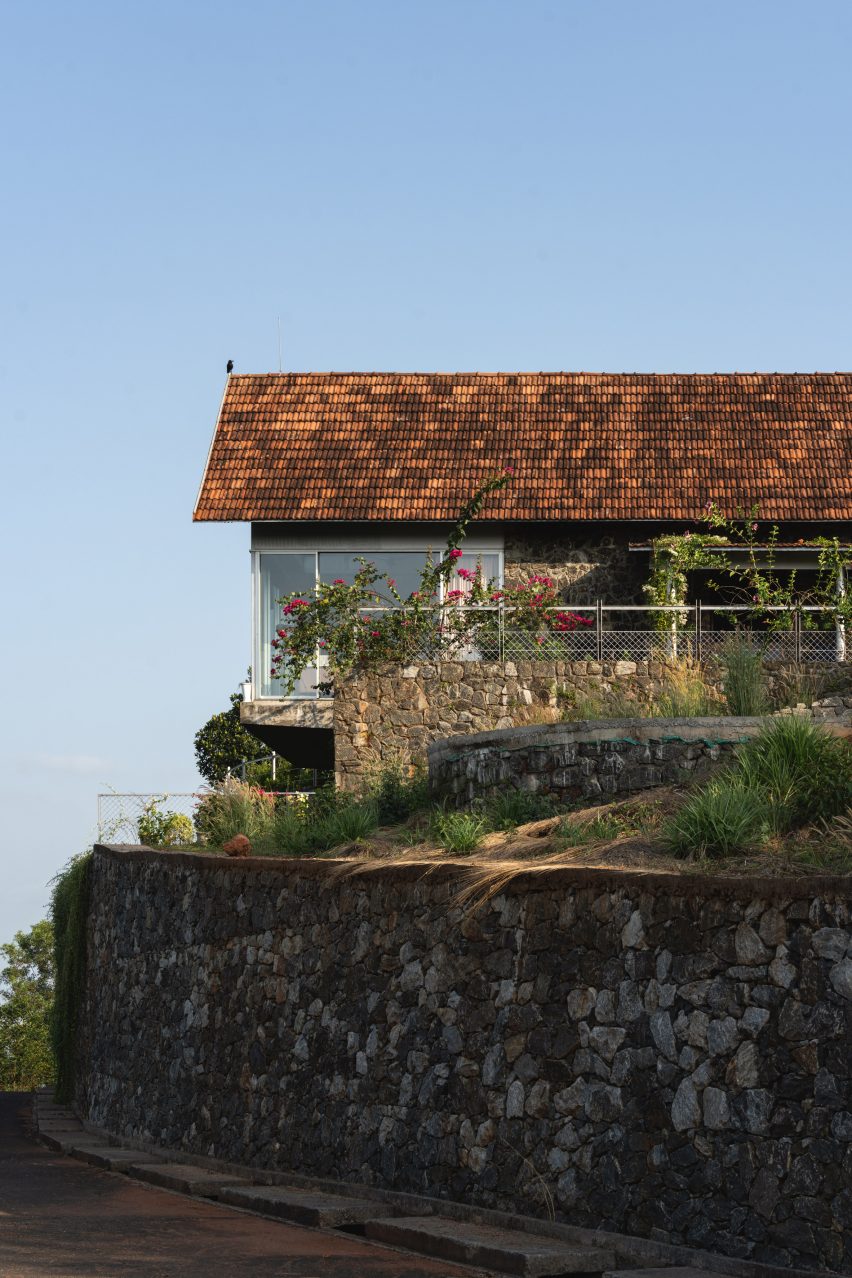 Ushas farmhouse on a stone retaining wall surrounded by planting