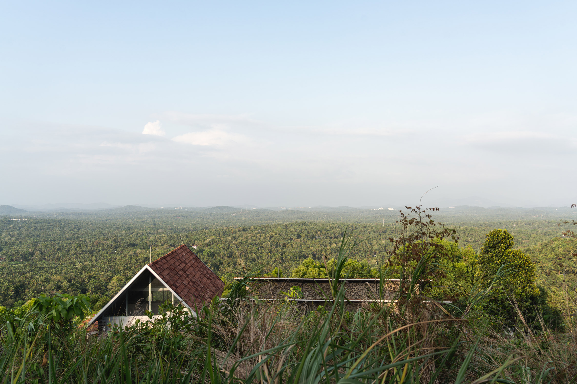 Ushas farmhouse overlooking a forested landscape in Kerala