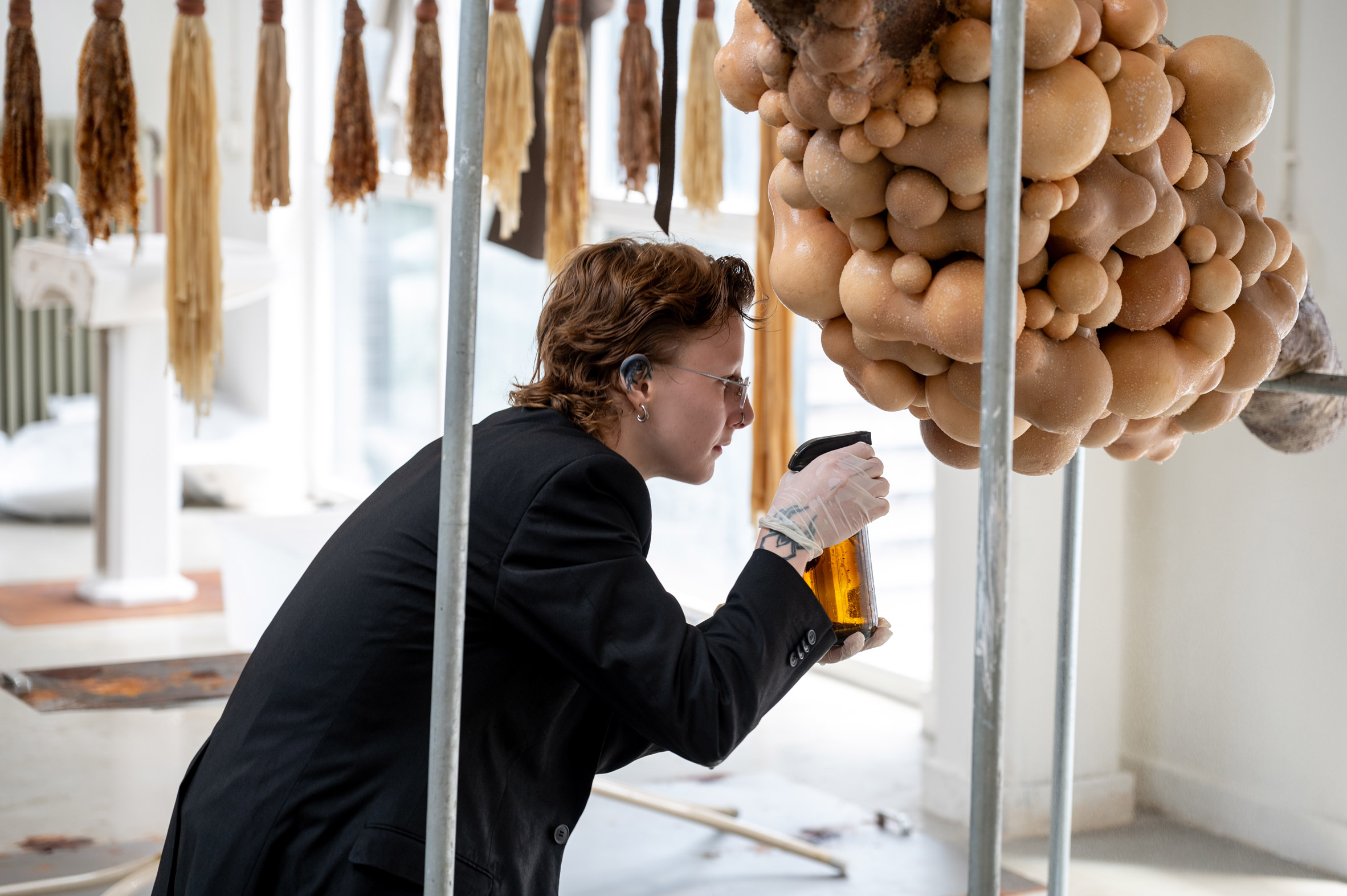 Student spraying a body-like installation