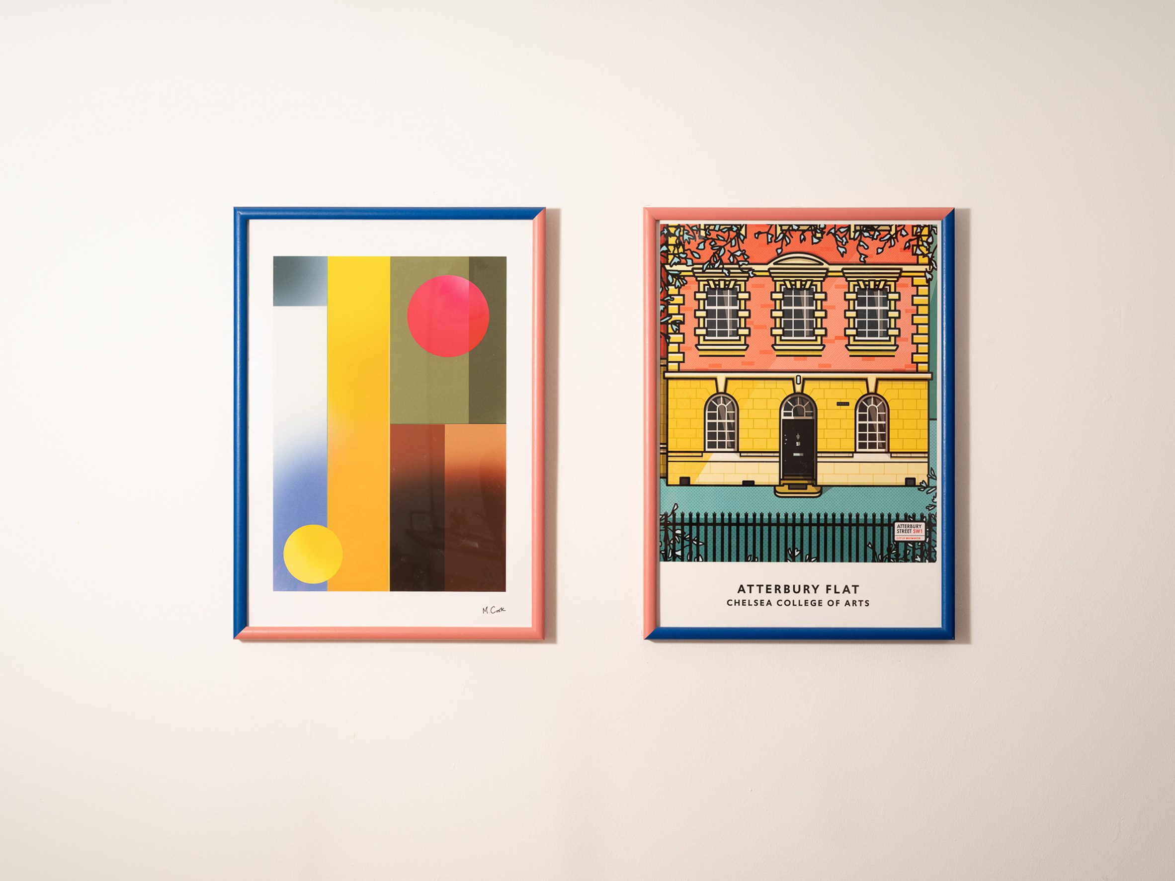 Photo of framed graphic prints on a white wall, one abstract, the other of a building facade