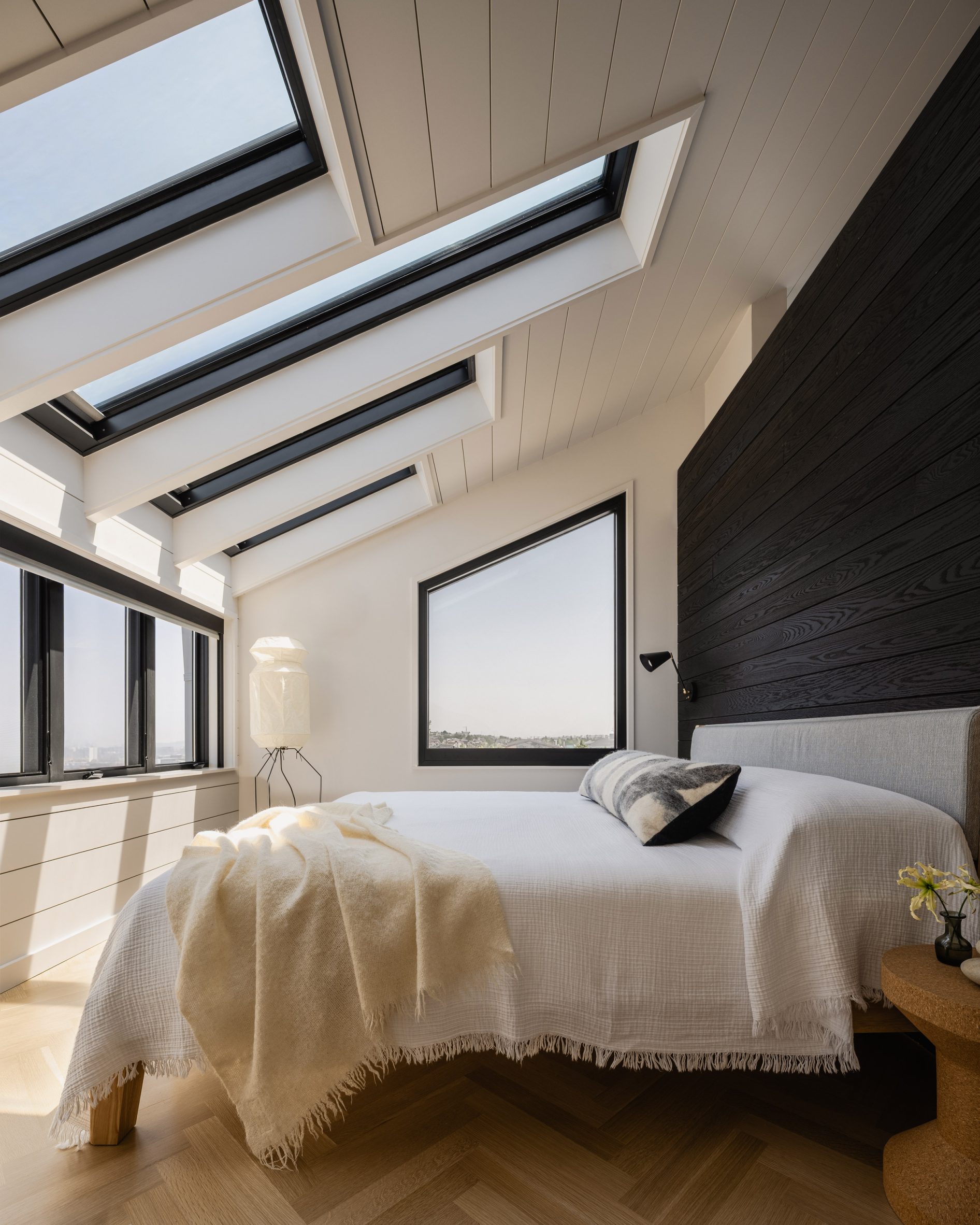 A primary bedroom oriented to face a row of windows and skylights for optimum views