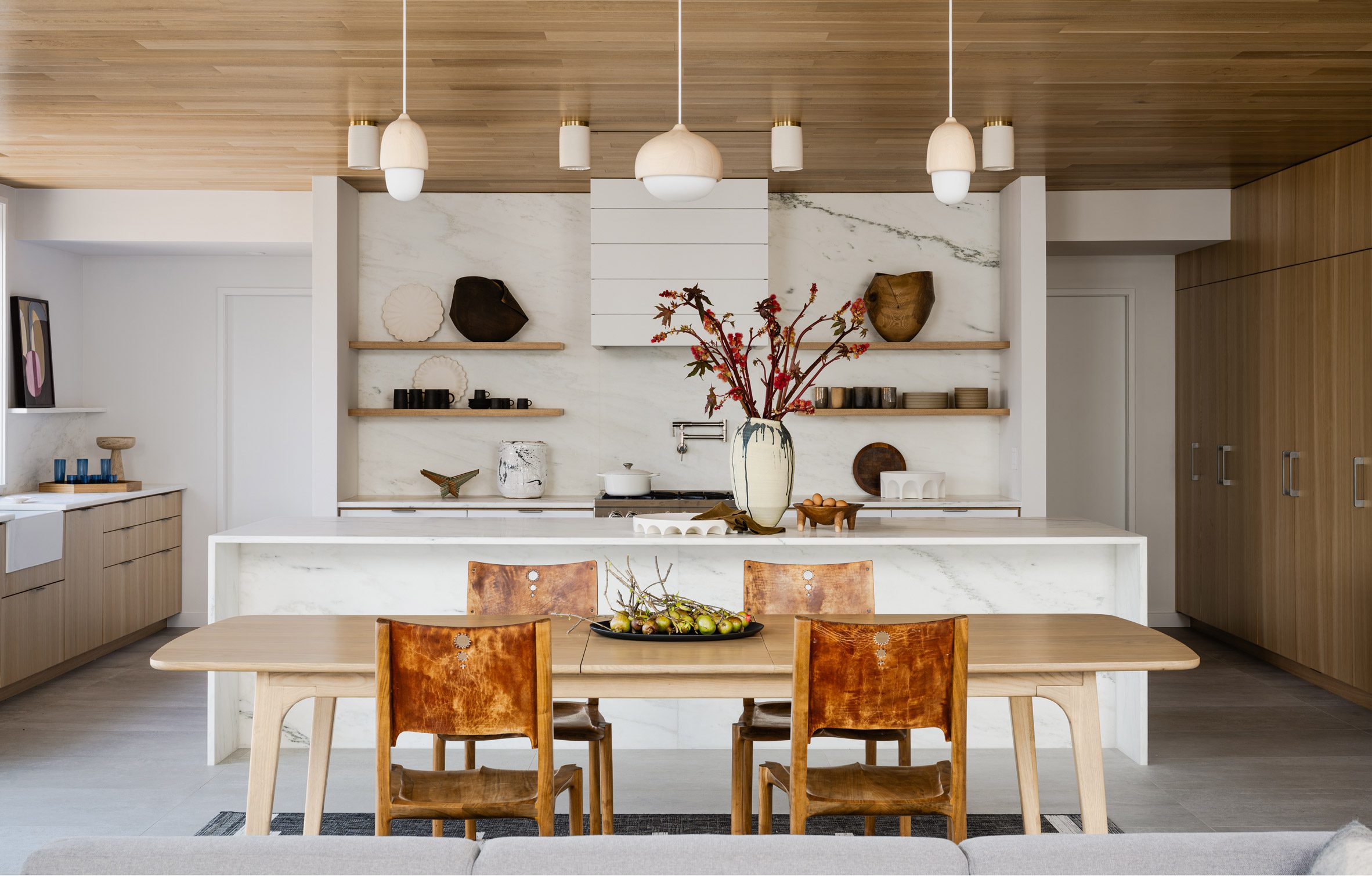 A marble and oak kitchen and dining area that spans the full width of the building