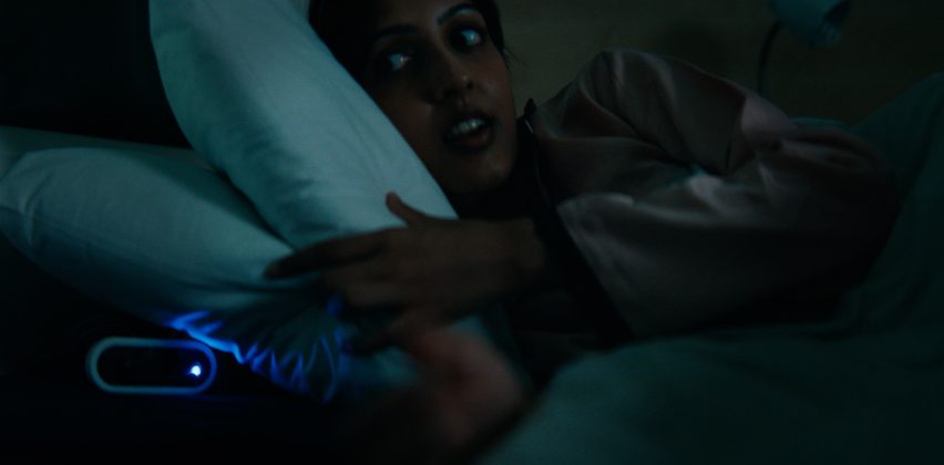 Person in bed reaching for an alarm