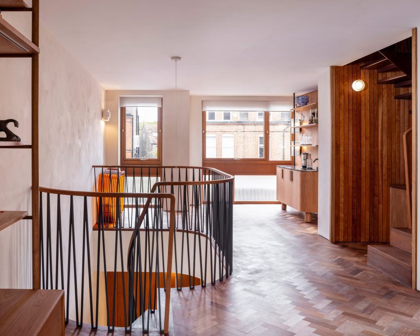 Curved landing with black metal balustrade overlooking the stairwell