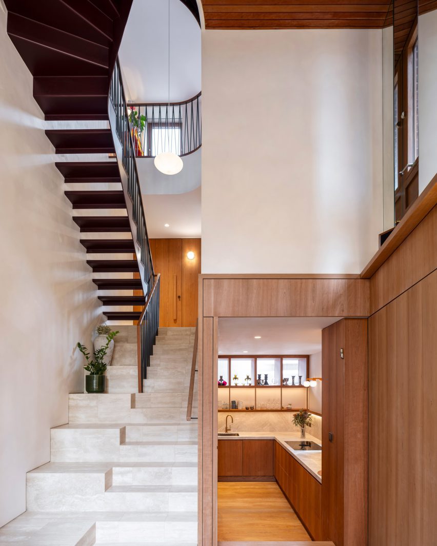 Marble staircase beside timber-lined walls and the central void