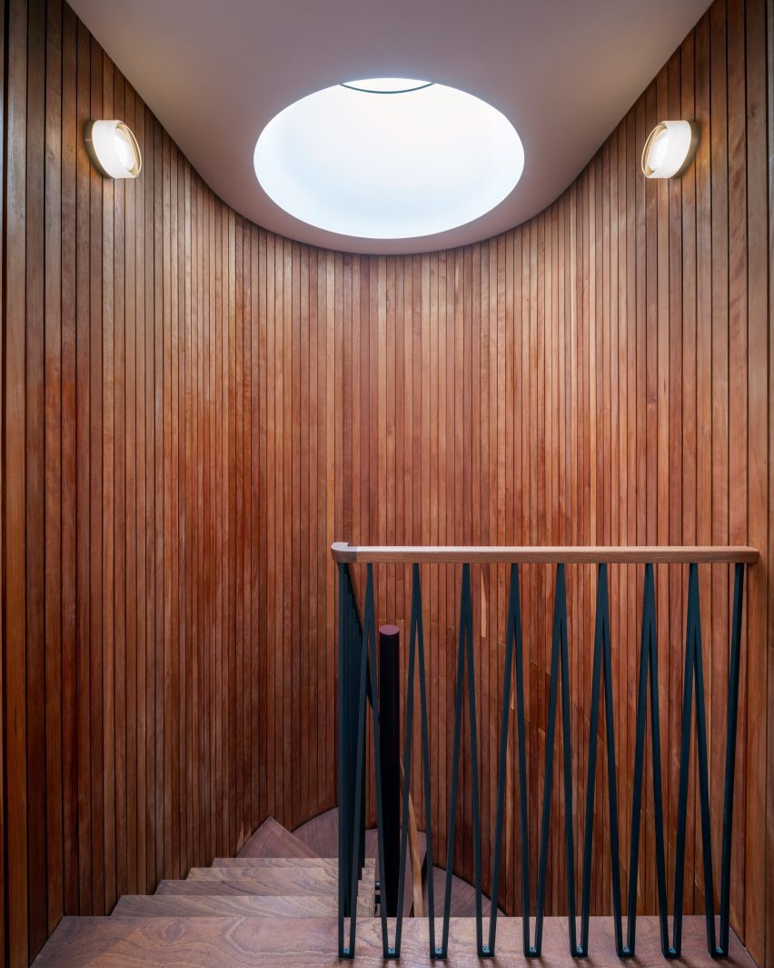 Curved timber staircase beneath a circular skylight