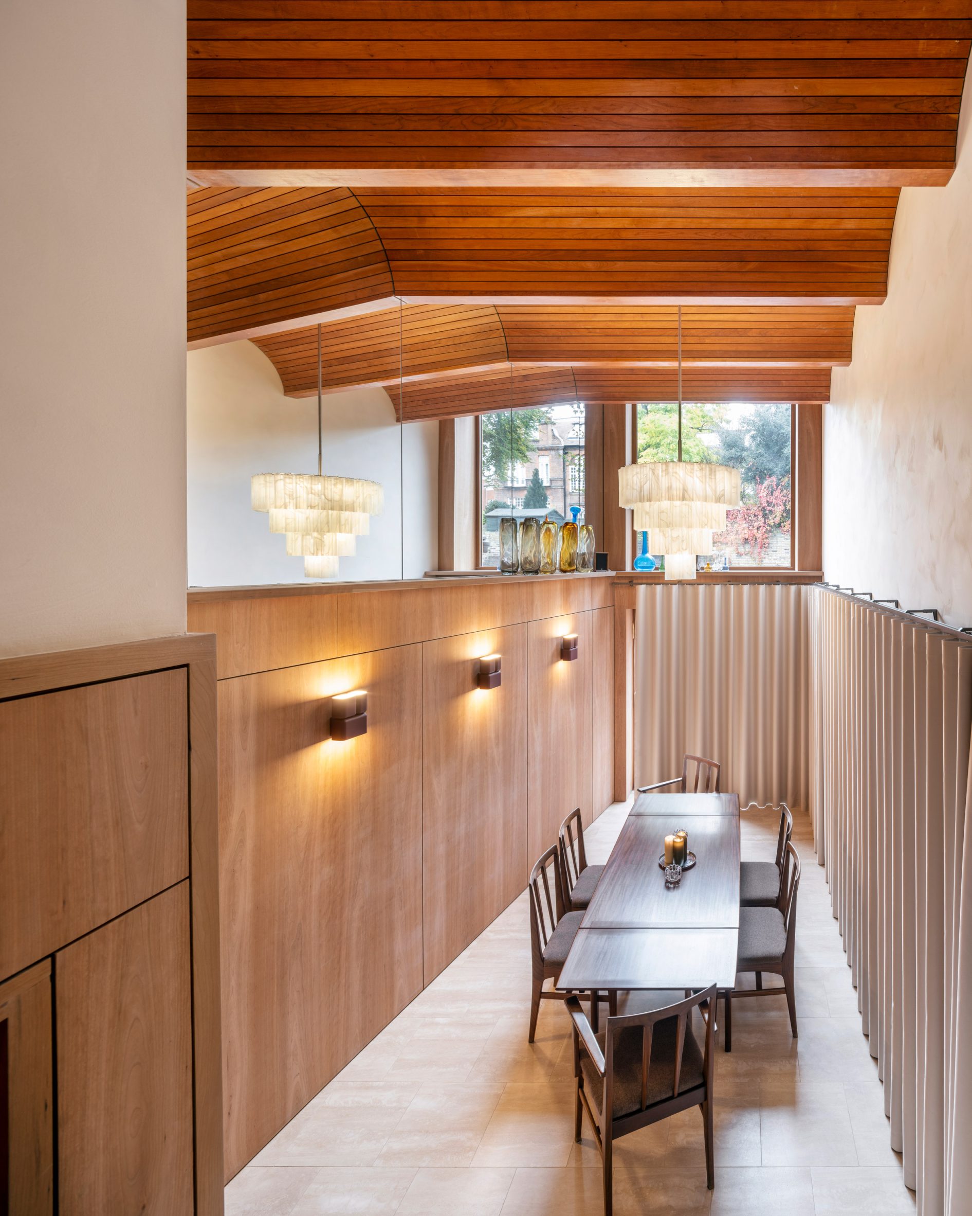 Double-height dining room with folded timber ceiling