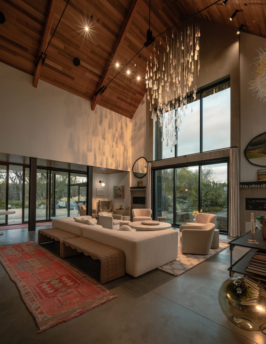 Herbarium chandelier suspended above a seating area in a double-height living room