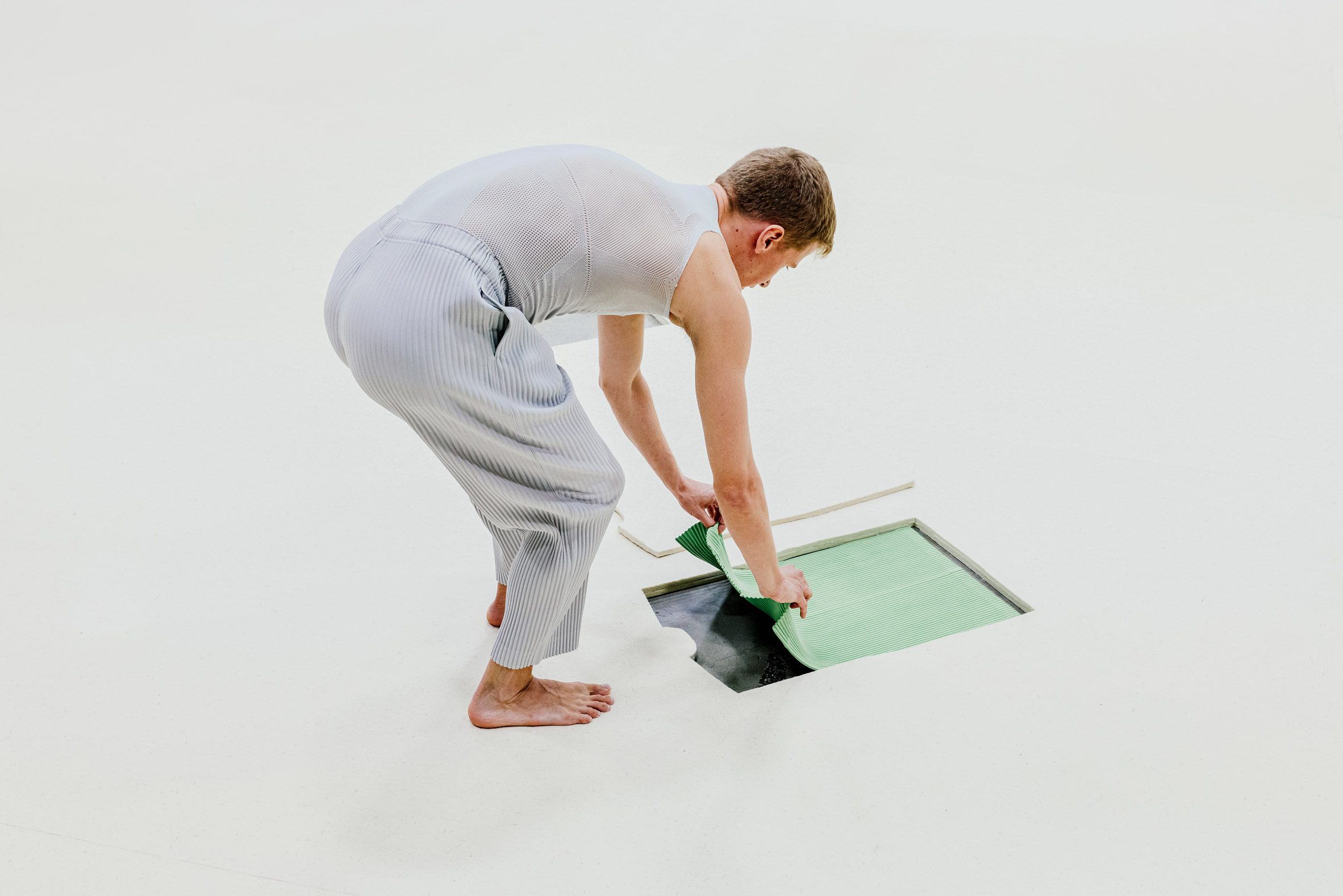 Man pulling clothes from floor