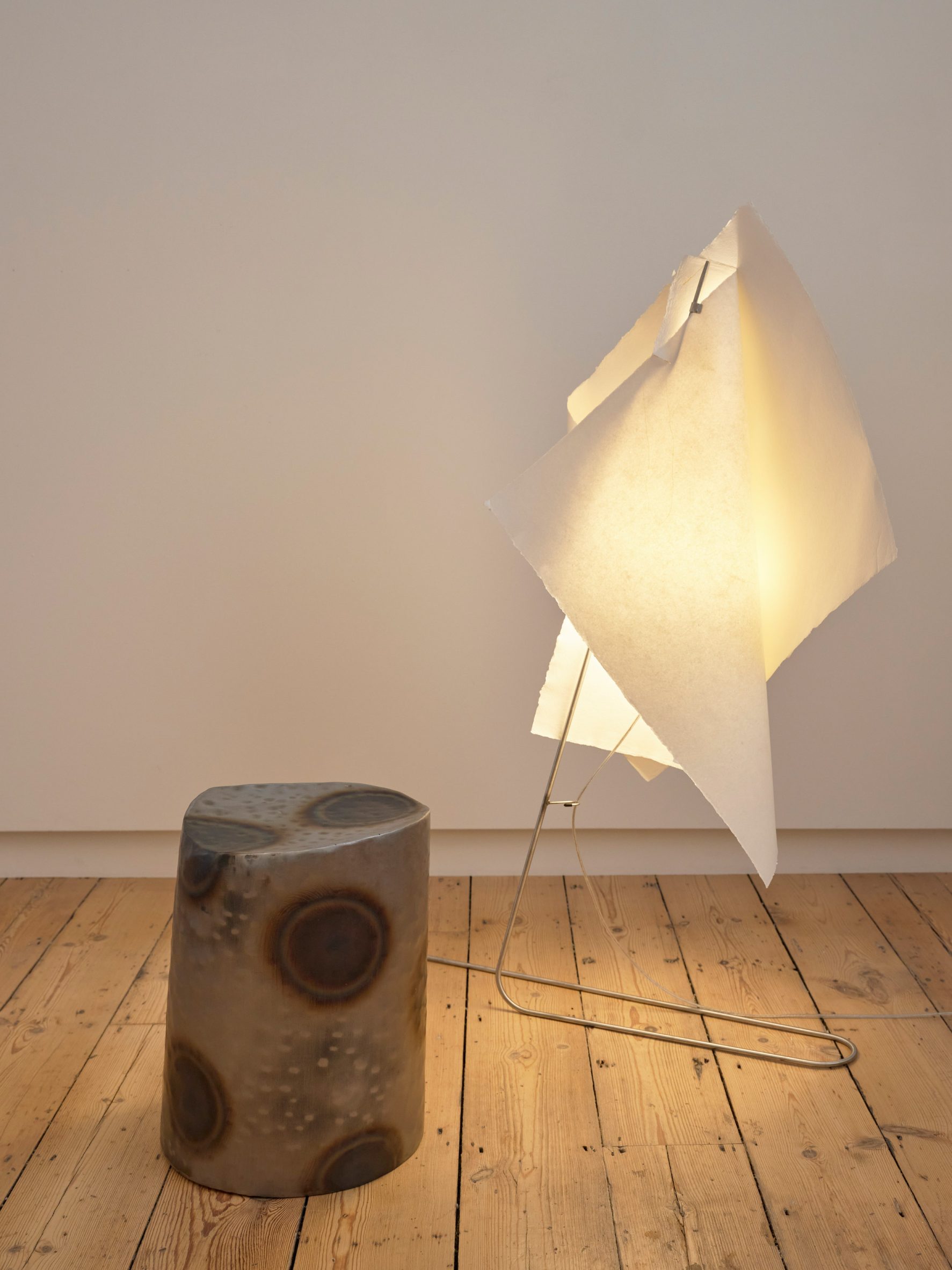 Metal stool next to paper lamp