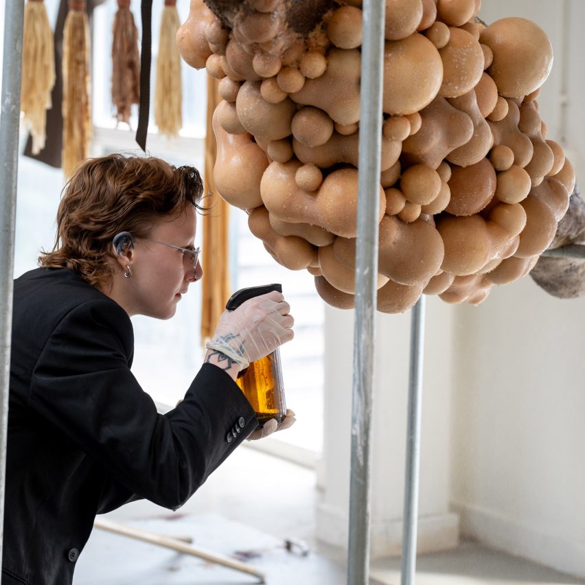 Student spraying a body-like installation