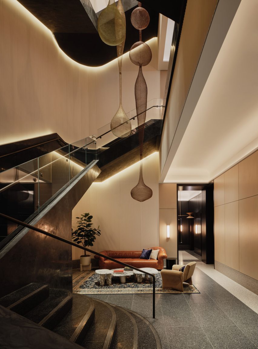 As blackened-steel staircase spirals up through a three-storey fluted atrium