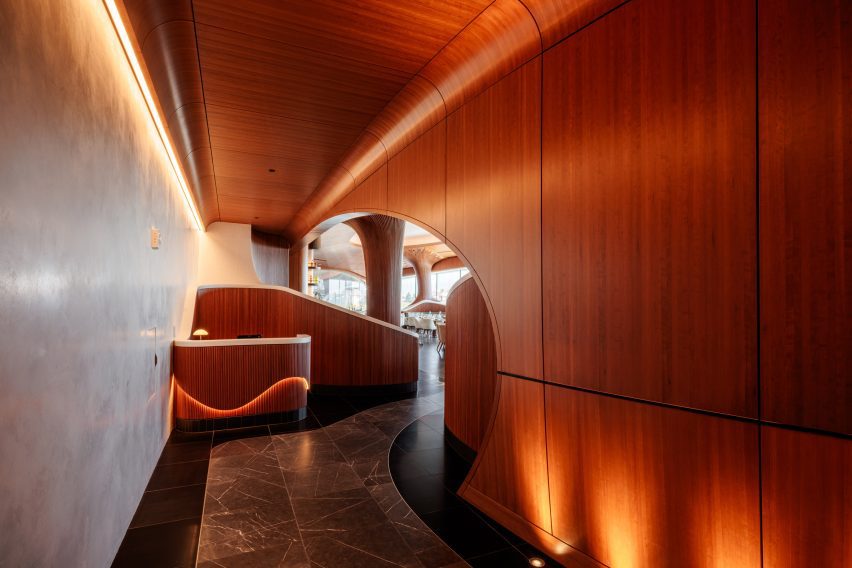 Entry to the fifth-floor restaurant along a corridor wrapped with cherry wood panels