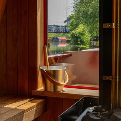Timber-lined sauna with a large picture window overlooking the canal