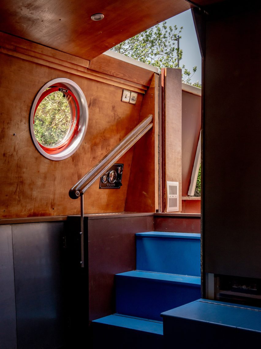 Blue steps beside a timber-lined changing area and circular porthole