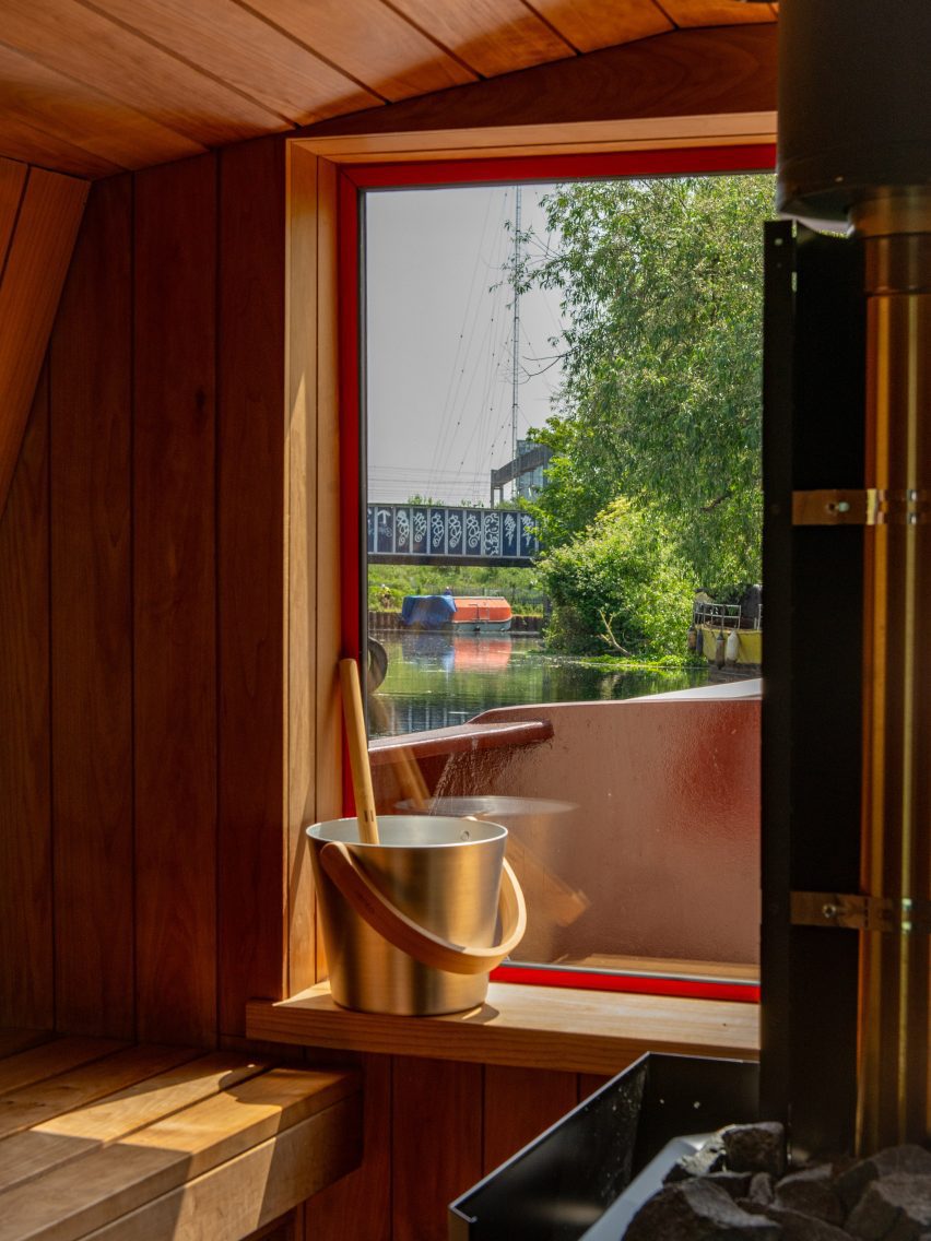 Timber-lined sauna with a large picture window overlooking the canal