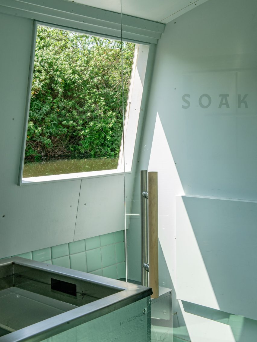 Stainless-steel plunge pool beside a large window overlooking trees and water