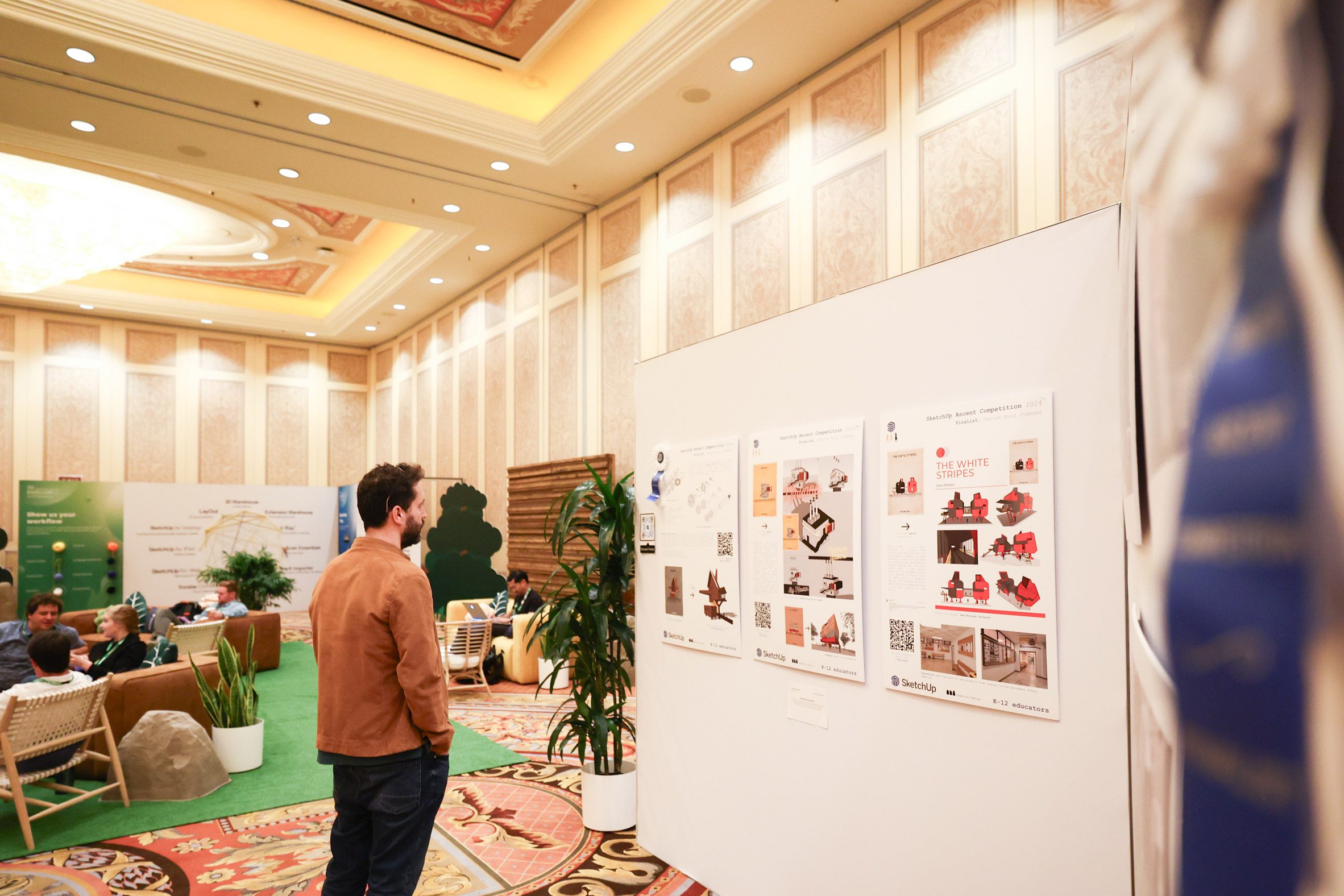 An attendee looking at presentation boards showing student projects 