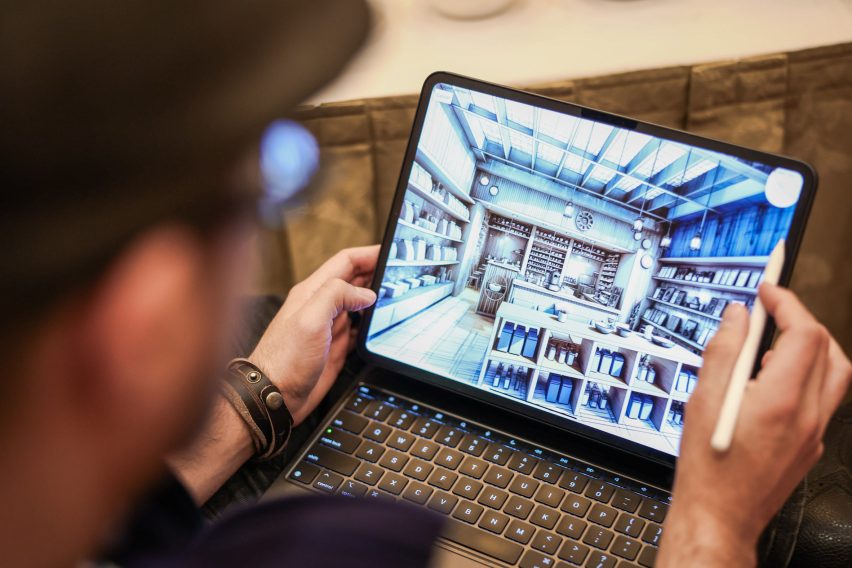 An attendee uses a stylus to navigate a detailed 3D interior model displayed on a tablet