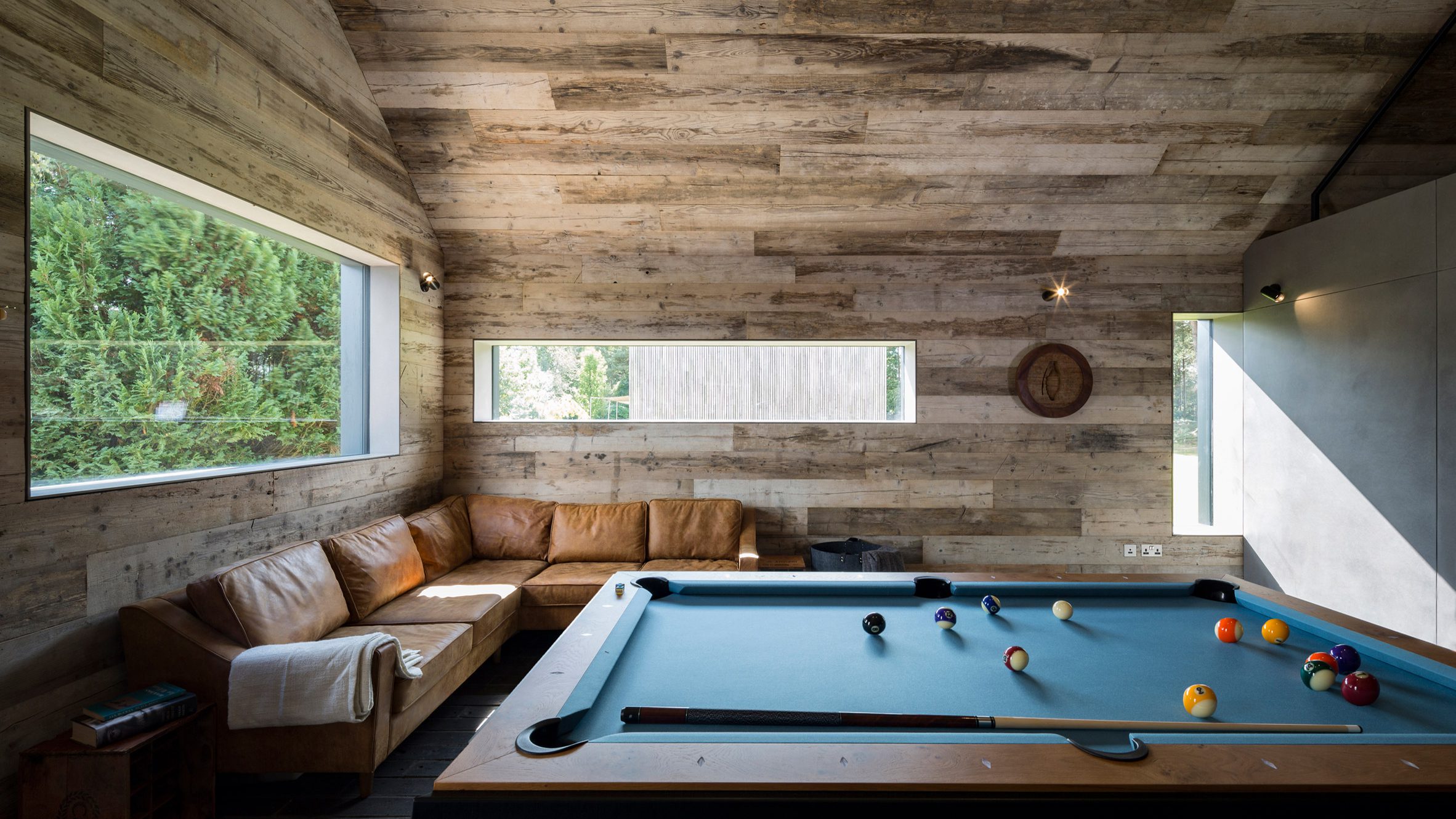 Blue pool table in wood-lined room
