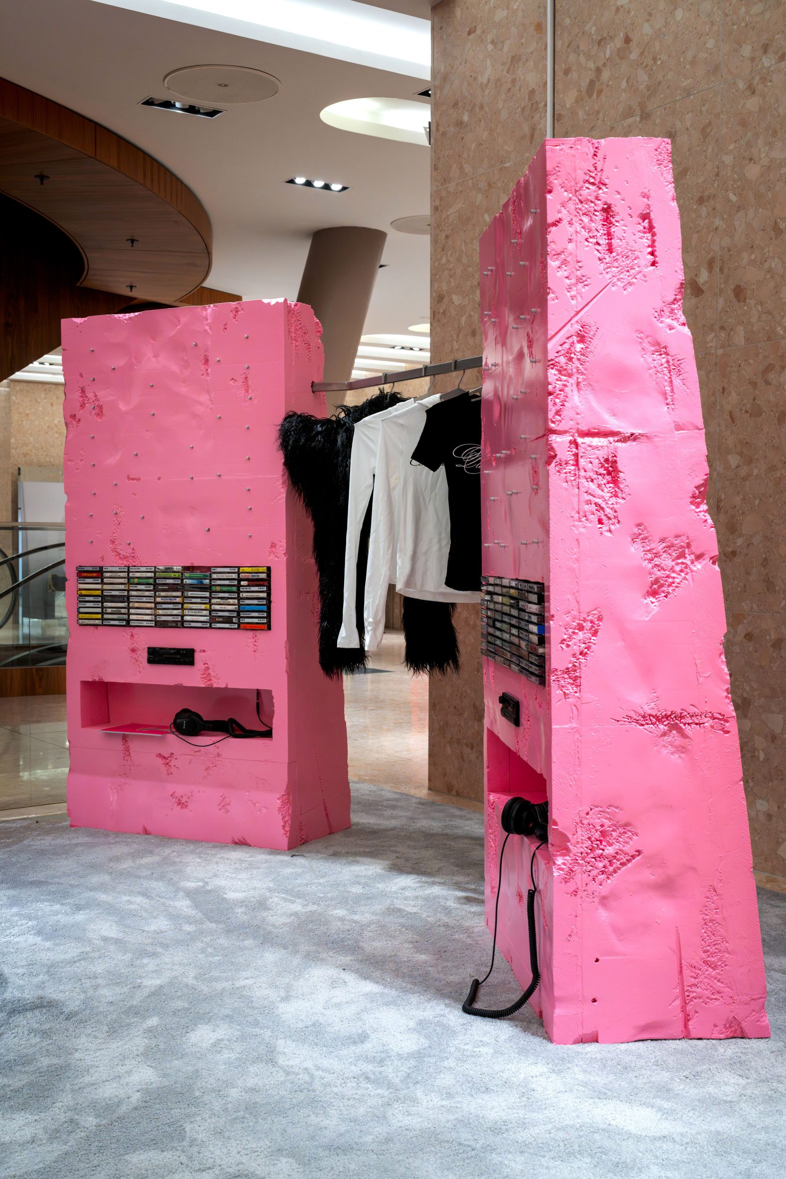 Two pink foam units holding cassette players and tapes