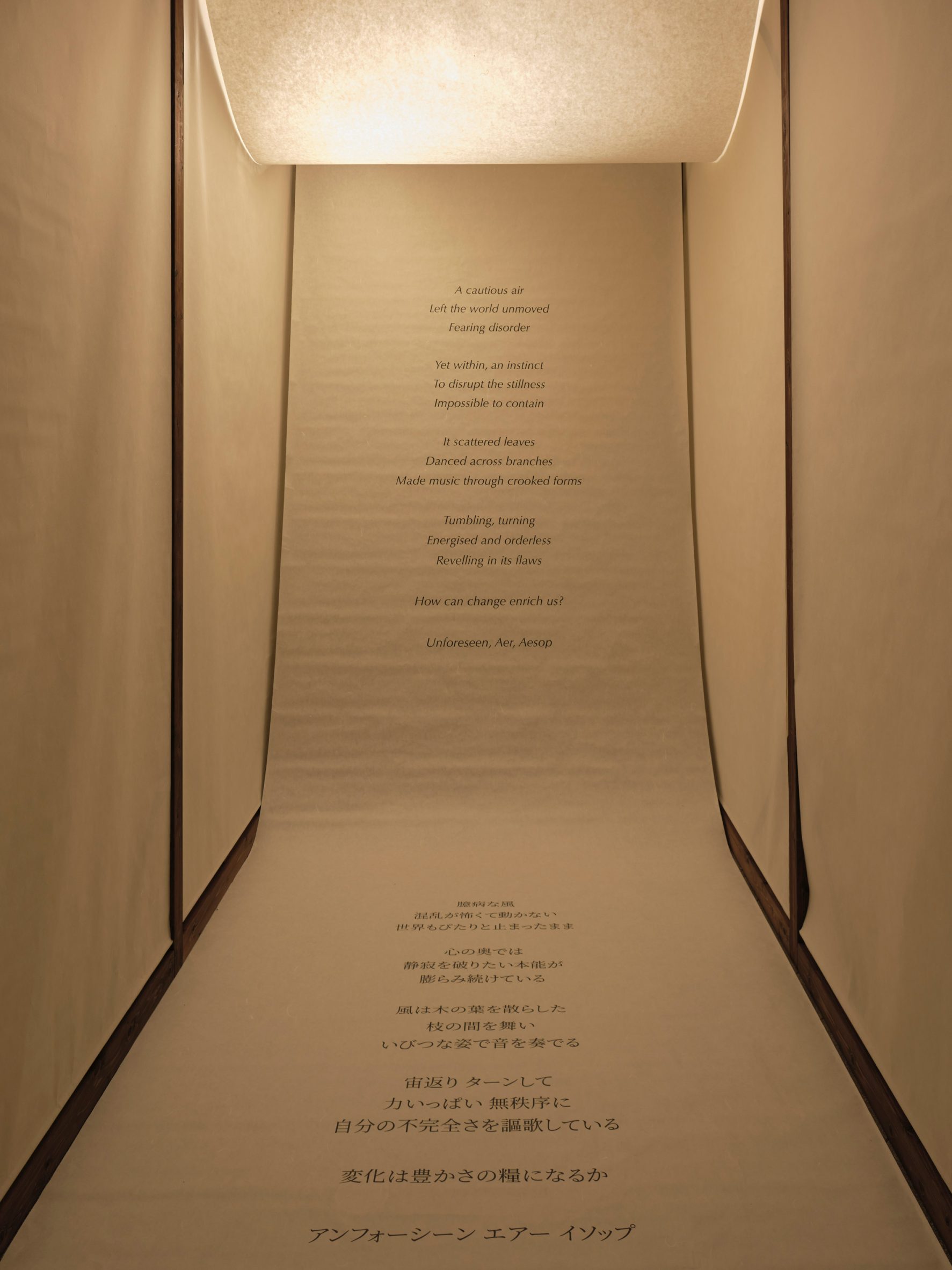 A large washi paper scroll displaying text framed by timber and surrounded by hanging paper