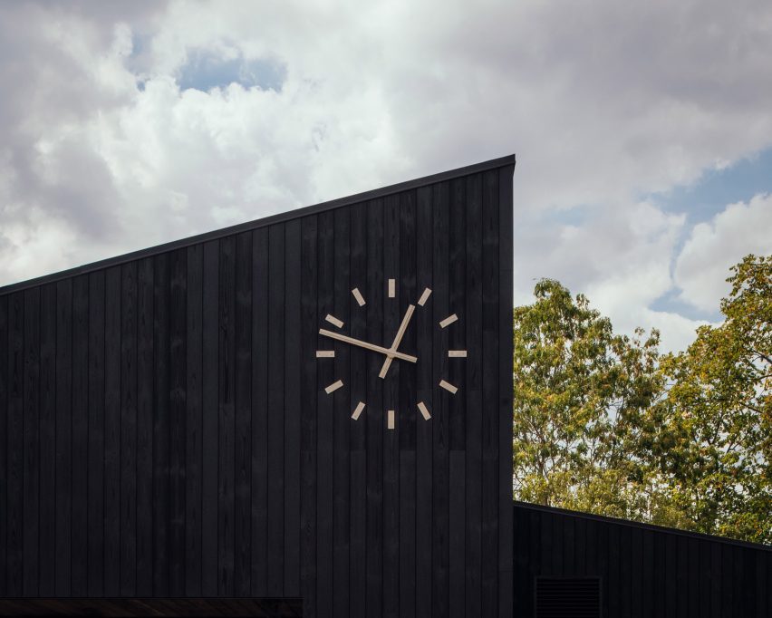 White clock on black cricket pavilion